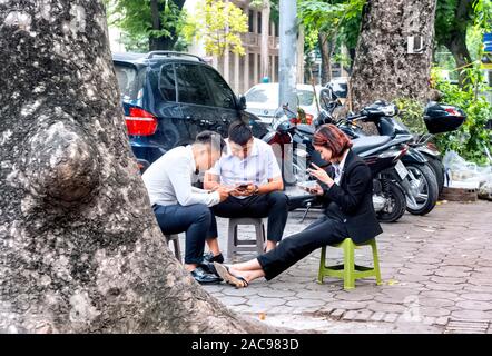 Petit groupe de personnes assises sur de petites chaises Hanoi Vietnam Banque D'Images