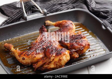 La cuisson du poulet dans une brique, également connu sous le nom de brick poulet, ou pollo al mattone, sur un gril Banque D'Images