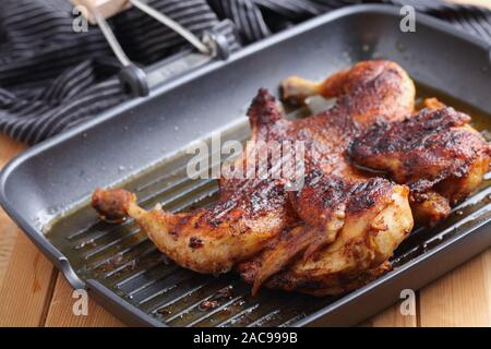 La cuisson du poulet dans une brique, également connu sous le nom de brick poulet, ou pollo al mattone, sur un gril Banque D'Images