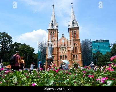 HO CHI MINH ville, VIETNAM - le 15 novembre 2019. La Cathédrale Notre Dame de Saigon avec des fleurs en premier plan Banque D'Images