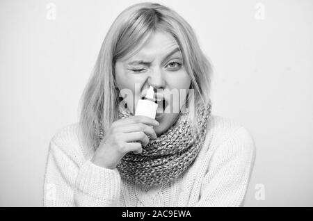 Le nettoyage. Femme malade médicament pulvérisation dans le nez. Mauvaise fille avec le nez à l'aide de spray nasal. Cute femme froide ou une allergie nasale de soins infirmiers. Tre Banque D'Images