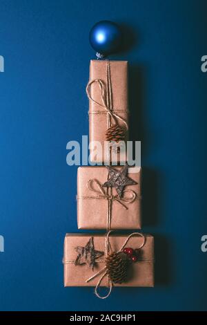Cadeaux de Noël Décoration avec énoncés dans la forme d'un arbre de Noël sur fond bleu, vue de dessus. Banque D'Images