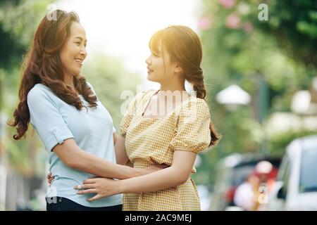 Mature Vietnamese woman looking at her smiling belle fille adultes Banque D'Images