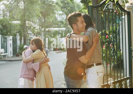 Les jeunes vietnamiens serrant leurs parents au moment de quitter la maison natale Banque D'Images