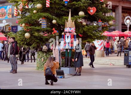 Deux jolies dames posant à côté d'une des statue Casse-noisette à côté de grand arbre de Noël en place au centre du marché de l'Avent. Zagreb, Croatie Banque D'Images