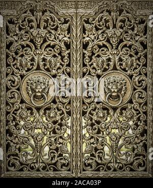 Un couple de panneaux de porte en fonte ouvragée avec les lions head heurtoirs de porte au milieu. Banque D'Images