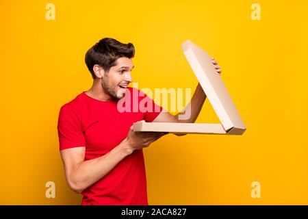 Portrait de stupéfié crazy guy tenir ouverte la boîte de pizza ne crois scream wow j'adore porter des vêtements de style décontracté sur fond de couleur jaune isolé Banque D'Images