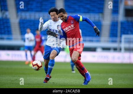 Joueur de football brésilien, Alan Kardec de Chongqing GDS, droite, luttes pour la balle durant le 30e match de football chinois Super League (CSL) contre Tianjin TEDA à Tianjin, Chine, 1 décembre 2019. Tianjin TEDA défait avec GDS Chongqing 2-0. Banque D'Images