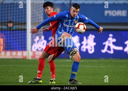 Joueur de football croate Ivan Santini de Jiangsu Suning F.C., droit, protège la balle au cours du 30e match de football chinois Super League (CSL) contre Tianjin Tianhai à Nanjing city, Jiangsu province de la Chine de l'Est, 1 décembre 2019. Shanghai Suning défait Tianjin Tianhai avec 2-0. Banque D'Images