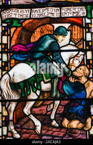 L'Angleterre, l'East Sussex, Eastbourne, Eastbourne College Chapel, vitrail représentant un chevalier sur un cheval blanc offrant l'aumône à un Begger Banque D'Images