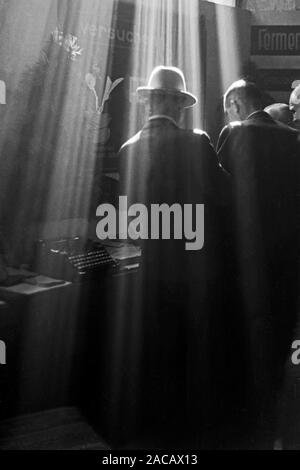 Messegänger begutachten einen Messestand, Leipzig, Saxe, Allemagne, 1948. Des visiteurs examinent un stand, Leipzig, Saxe, Allemagne, 1948. Banque D'Images