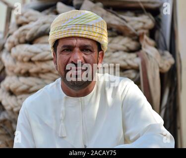 Sur, Oman, novembre 19rd, 2018 : l'homme fait dans l'omanais shipyard construction de nouveaux bateaux en bois traditionnels - dau, dans l'arrière-plan de voile épais r Banque D'Images