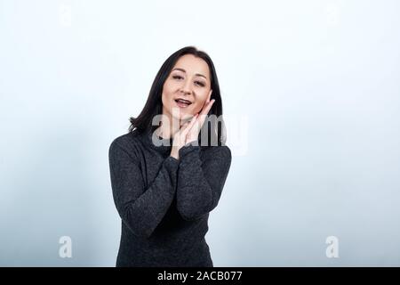 Sleepy caucasian woman main sur joue, faisant le geste de sommeil, smiling Banque D'Images