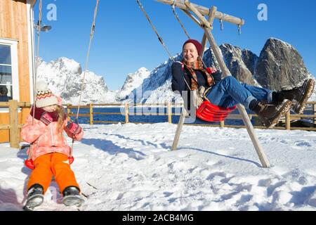 Fun heureux la vie. Soeur des filles sur une balançoire oscillante à l'Iles Lofoten. La Norvège Banque D'Images