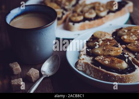 Délicieux petit-déjeuner français - toast avec du chocolat et bananes frites sur fond de bois Banque D'Images