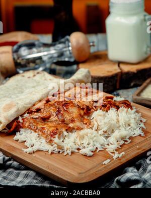 Poulet frit avec du riz bouilli sur une planche en bois Banque D'Images