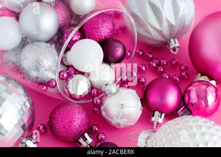 Boules de Noël dans un verre à vin sur un fond rose close up Banque D'Images