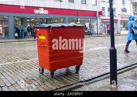 Un large red Biffa wheelie bin en attente pour la collecte et le vidage dans Boscawen Street dans le centre-ville de Truro à Cornwall. Banque D'Images