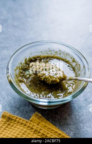 Sauce à salade aux herbes vert fait maison avec les racines des plantes dans la cuvette en verre avec une cuillère. Cuisine maison bio. Banque D'Images