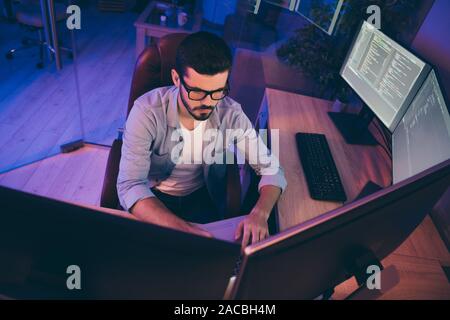 Photo de spécialiste des technologies de l'information guy assis fauteuil confortable, tenant les mains sur le clavier à la plupart des moniteurs site test expert développeur sérieux de débogage Banque D'Images