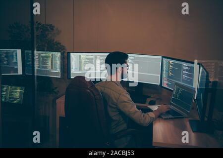 Vue du côté de son profil il attrayant nice qualifié grave intelligent Smart Guy Brunet barbus geek nerd faisant rapport de bug tracking seo web blockchain Banque D'Images