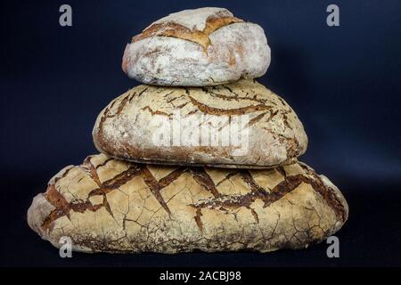 Trois Loafs (ou des miches de pain au levain français), ainsi qu'appelé pain de campagne, empilé isolé sur un fond noir. Pain de Campagne est un exemple typique de F Banque D'Images