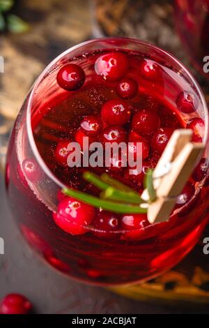 Cocktail aux canneberges avec le romarin dans deux verres sur fond sombre. Banque D'Images