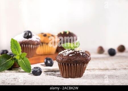 Muffins aux bleuets et chocolat blanc sur un fond de bois. Banque D'Images
