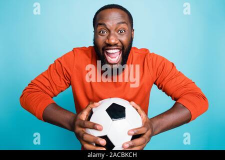Portrait of cheerful heureux les heureux homme extatique holding ball se réjouir dans l'objectif de son équipe favorite plus isolés des couleurs vives bleu Banque D'Images