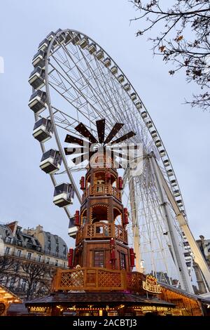 PARIS, FRANCE - 30 NOVEMBRE 2019 : tour en bois géant et une grande roue à l'arrière-plan dans le marché de Noël au Jardin des Tuileries à Paris. Banque D'Images