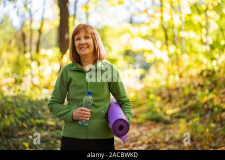 Happy senior femme est prête pour l'exercice en parc.