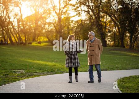 Happy senior couple marche dans le parc en automne. Banque D'Images