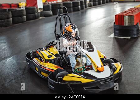 Des animations pour les enfants à l'intérieur. Girl driving go kart sur la piste. Mode de vie actif. Banque D'Images