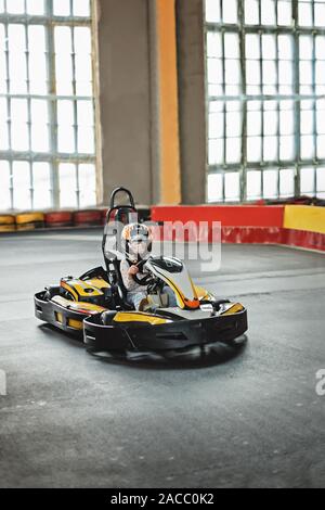 Des animations pour les enfants à l'intérieur. Girl driving go kart sur la piste. Mode de vie actif. Banque D'Images