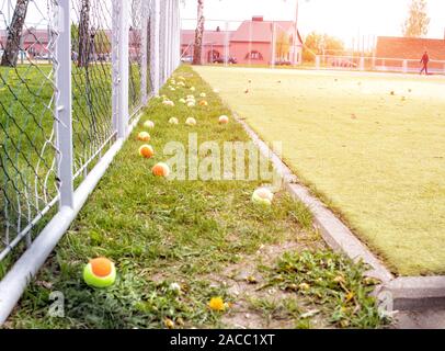 Grand terrain de tennis avec l'herbe verte et de boules colorées. Sports et tennis concept, l'arrière-plan, l'espace de copie, le mode de vie Banque D'Images