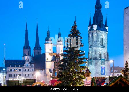 Halle, Allemagne. 22 Nov, 2019. Un arbre de Noël avec des boules rouges et blanches se dresse devant l'église du marché et la tour rouge de Halle. Sur la place en face de l'église, le marché de Noël annuel a lieu traditionnellement dans la Saale ville. Credit : Stephan Schulz/dpa-Zentralbild/ZB/dpa/Alamy Live News Banque D'Images