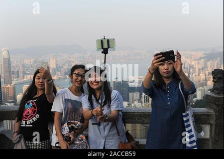 12.10.2014, à Hong Kong, Chine, Asie - Touristes prendre des autoportraits sur haut de Victoria Peak avec avec la ville et le port de Victoria dans la toile. Banque D'Images