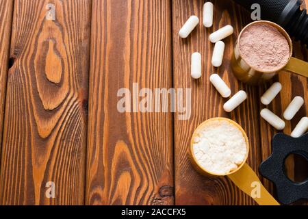 La nutrition sportive et du cou d'haltère sur un fond de bois Banque D'Images