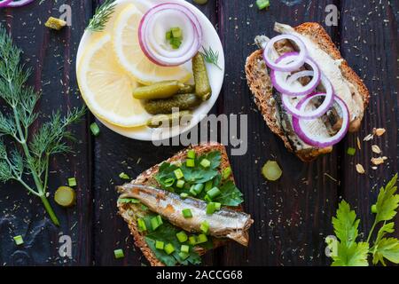 Sandwiches de poissons et une plaque avec des oignons citron et cornichons Banque D'Images