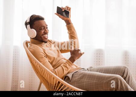 Le Chant de l'homme positif l'écoute de musique portant des écouteurs séance piscine Banque D'Images