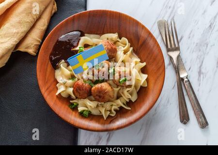 Swedish meatballs with mini cure-dent du pavillon et sauce nouilles jelly in wooden bowl Banque D'Images