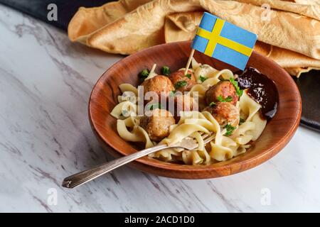 Swedish meatballs with mini cure-dent du pavillon et sauce nouilles jelly in wooden bowl Banque D'Images