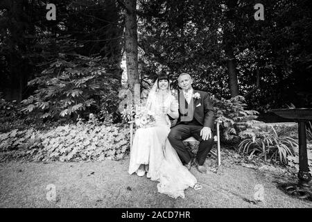 Mariés et mariés posent pour leurs photos après la cérémonie dans les jardins de l'hôtel Manor, B & B à Cheadle, Stoke on Trent, Staffordshire, jour du mariage Banque D'Images