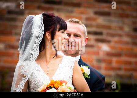 Mariés et mariés posent pour leurs photos après la cérémonie dans les jardins de l'hôtel Manor, B & B à Cheadle, Stoke on Trent, Staffordshire, jour du mariage Banque D'Images