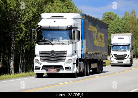 Mercedes-Benz Actros blanc et les camions Iveco tracter des remorques le long de l'autoroute 25 en direction de port de Hanko en été. Raasepori, Finlande. Le 12 juillet 2019. Banque D'Images