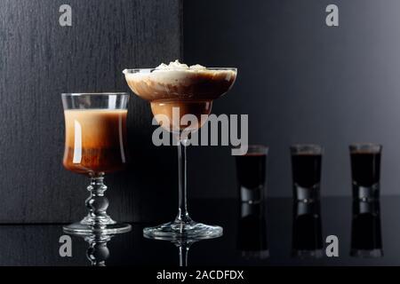 Des cocktails et de l'alcool de café noir sur fond réfléchissant. Copie de l'espace pour votre texte. Banque D'Images