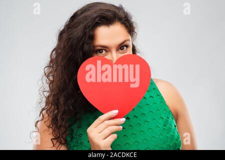 Happy woman in green dress holding red heart Banque D'Images