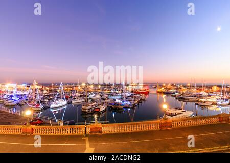 Heure bleue au port de Ramsgate dans le Kent, en Angleterre. Le ciel crépuscule sur un port rempli de petits bateaux et yachts, beaucoup d'entre eux décorés de lumières de Noël dans le cadre du festival de Noël. Banque D'Images