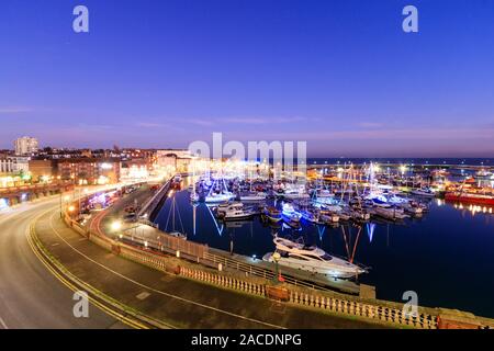 Heure bleue au port de Ramsgate dans le Kent, en Angleterre. Le ciel crépuscule sur un port rempli de petits bateaux et yachts, beaucoup d'entre eux décorés de lumières de Noël dans le cadre du festival de Noël. Banque D'Images