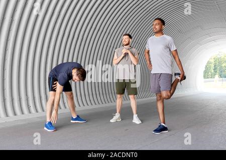 Les hommes ou les amis masculins les étirements avant la formation Banque D'Images